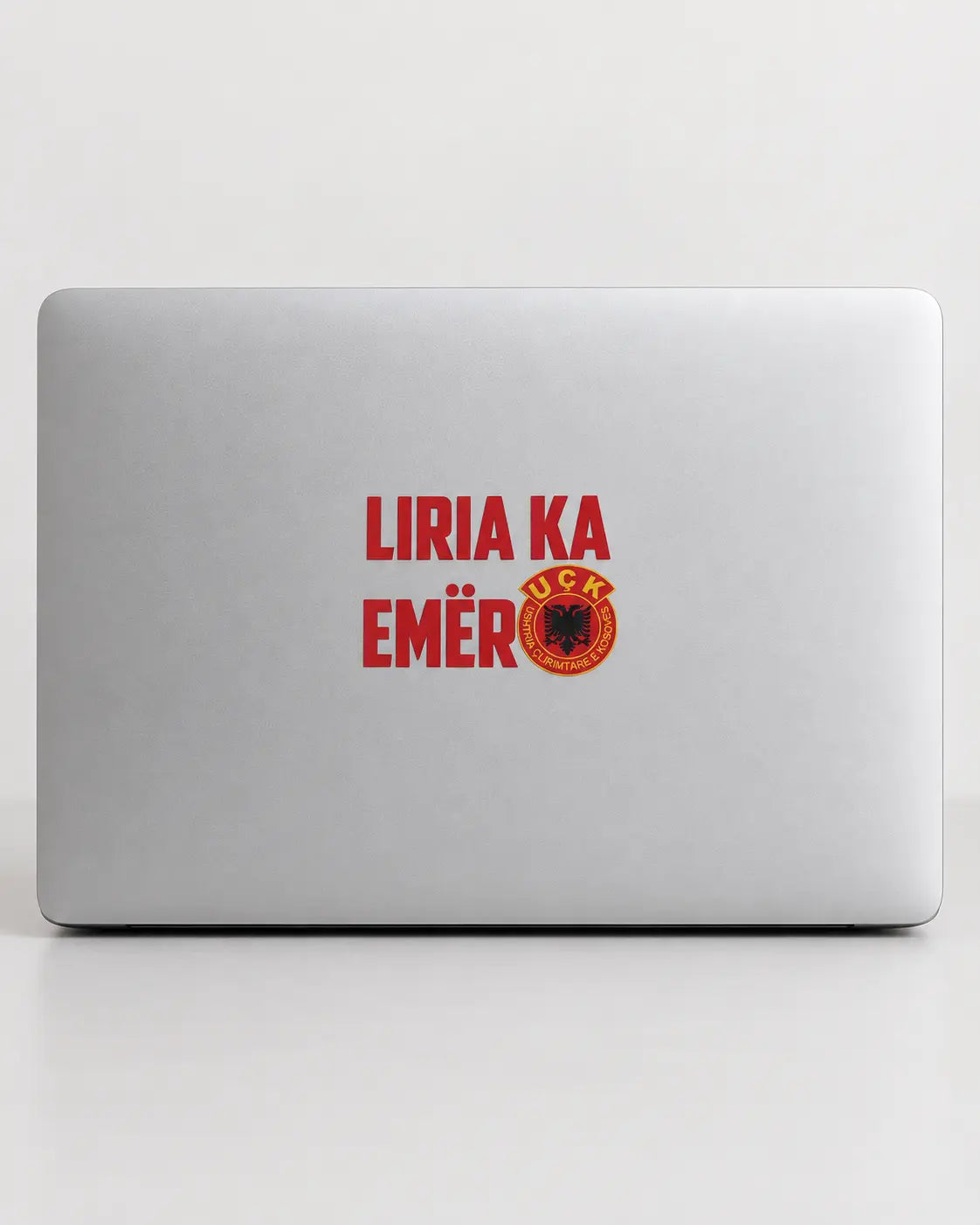 Autocollant Liria Ka Emër rouge collé sur un capot d'ordinateur portable argenté