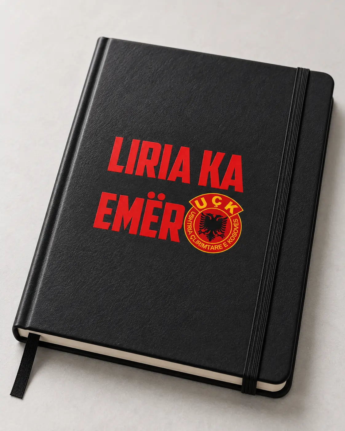 Autocollant Liria Ka Emër rouge sur un carnet noir