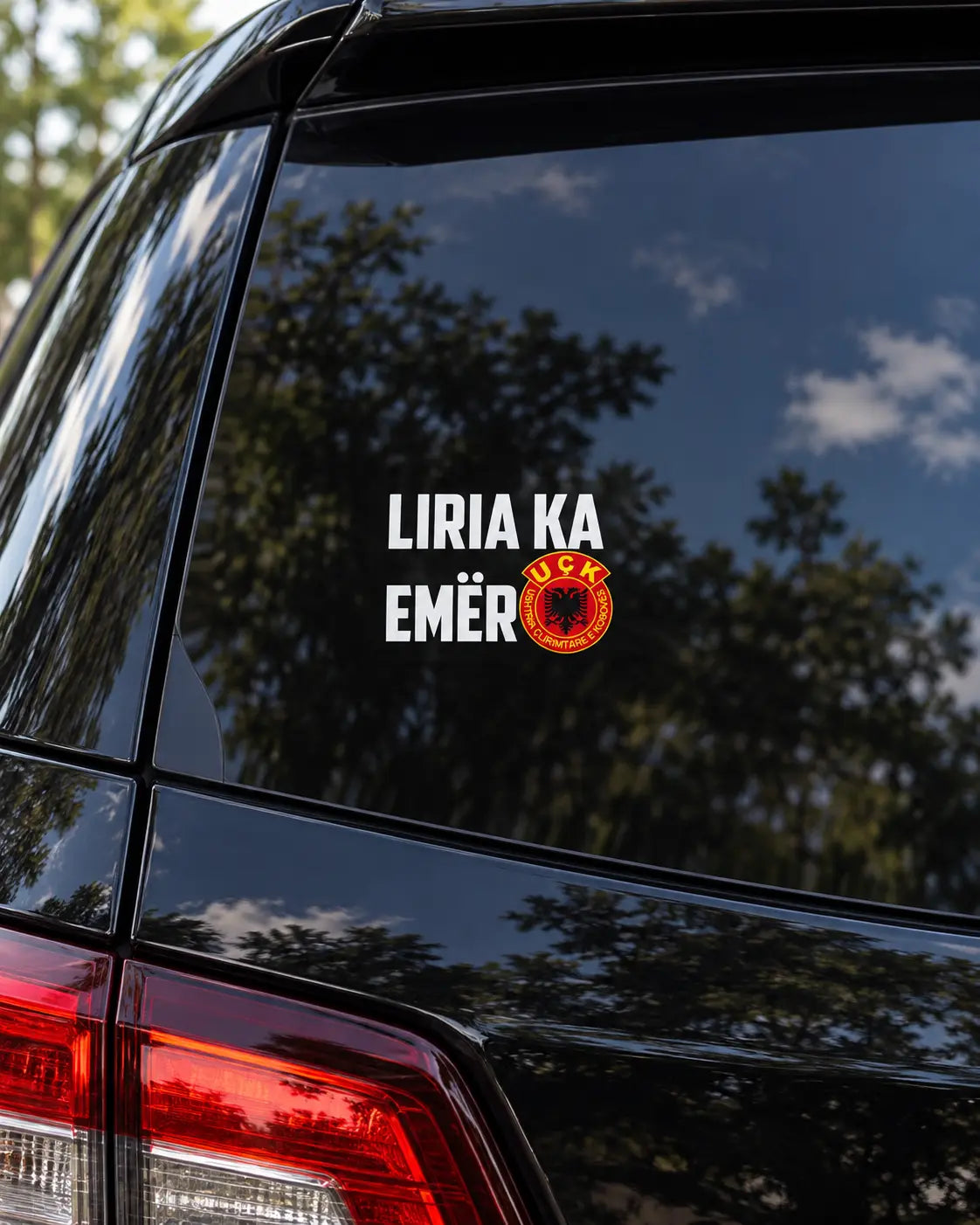 Autocollant Liria Ka Emër blanc sur la vitre arrière teintée d'une voiture