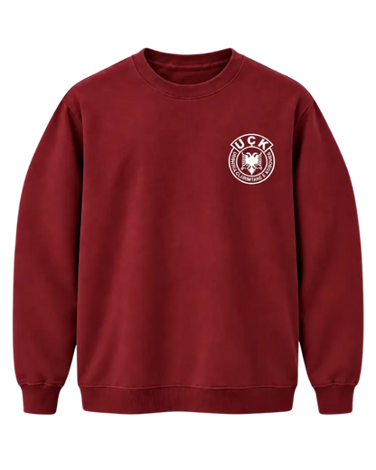 Front of the burgundy Jo në emrin tim sweatshirt with the white UÇK emblem on the left chest
