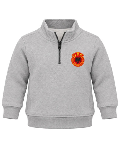 UÇK Baby Pullover in Grau – Troyer mit Stehkragen, Reißverschluss und gesticktem UÇK-Emblem auf der linken Brust, Vorderansicht